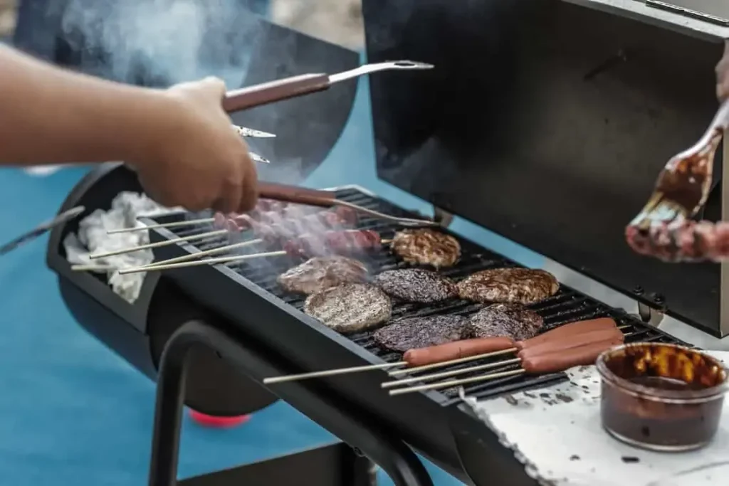 Grilling burgers and sausages on a BBQ grill that needs regular cleaning